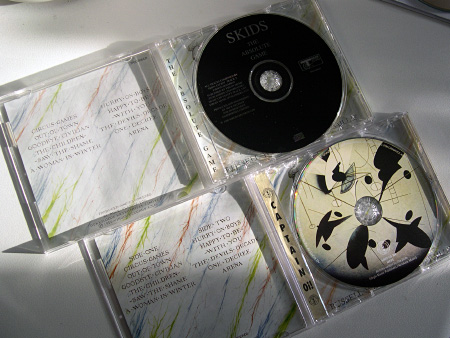 Skids 'The Absolute Game' UK CD issues - Track records issue label and inner tray (left) and second Captain Oi! issue label and inner tray (right)