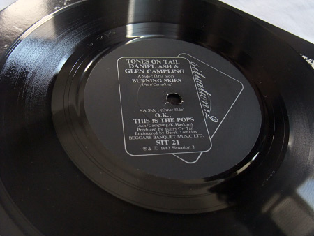 Tones On Tail - Burning Skies / OK This is The Pops 7 inch single side 1 label design