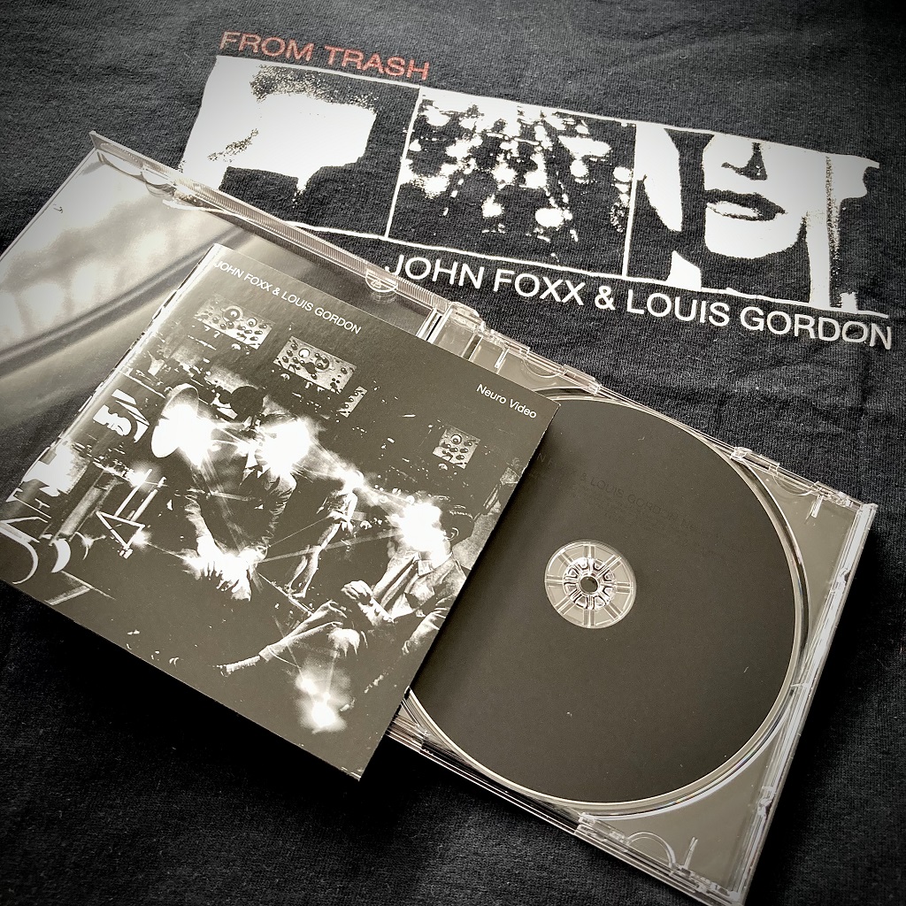 John Foxx and Louis Gordon - 'Neuro Video' live CD front cover and disc and 'From Trash' T-shirt in the background