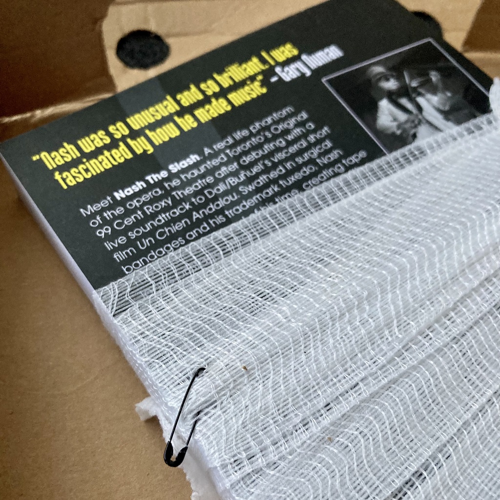 Nash The Slash 'Cut-Throat' book unboxing - book back cover bandaged and safety pinned detail